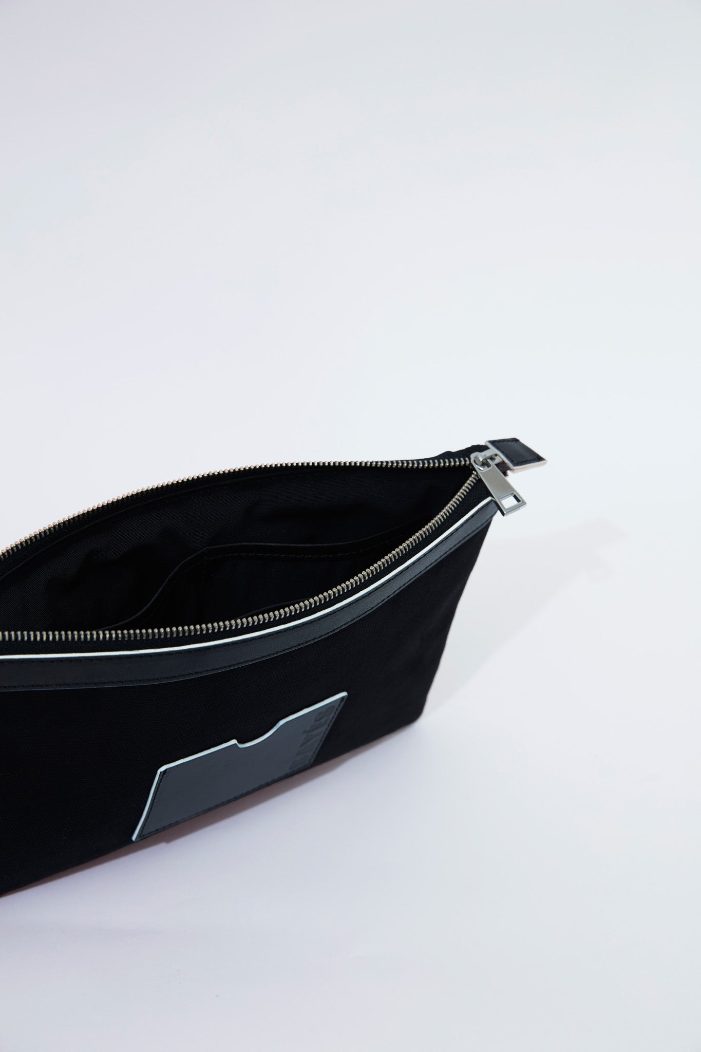 STITCHED CLUTCH IN BLACK WITH OFF-WHITE EDGES