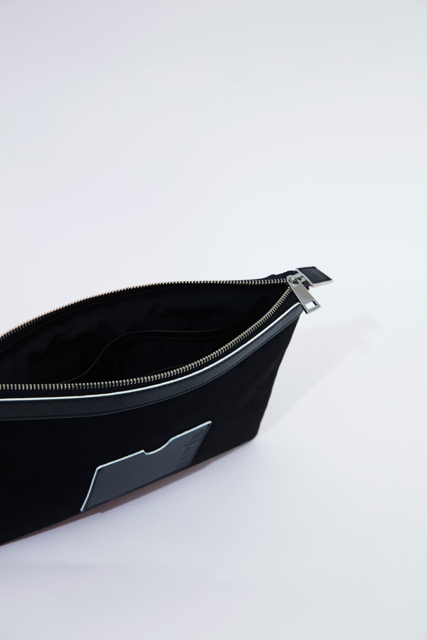 STITCHED CLUTCH BAG IN BLACK WITH OFF-WHITE EDGES